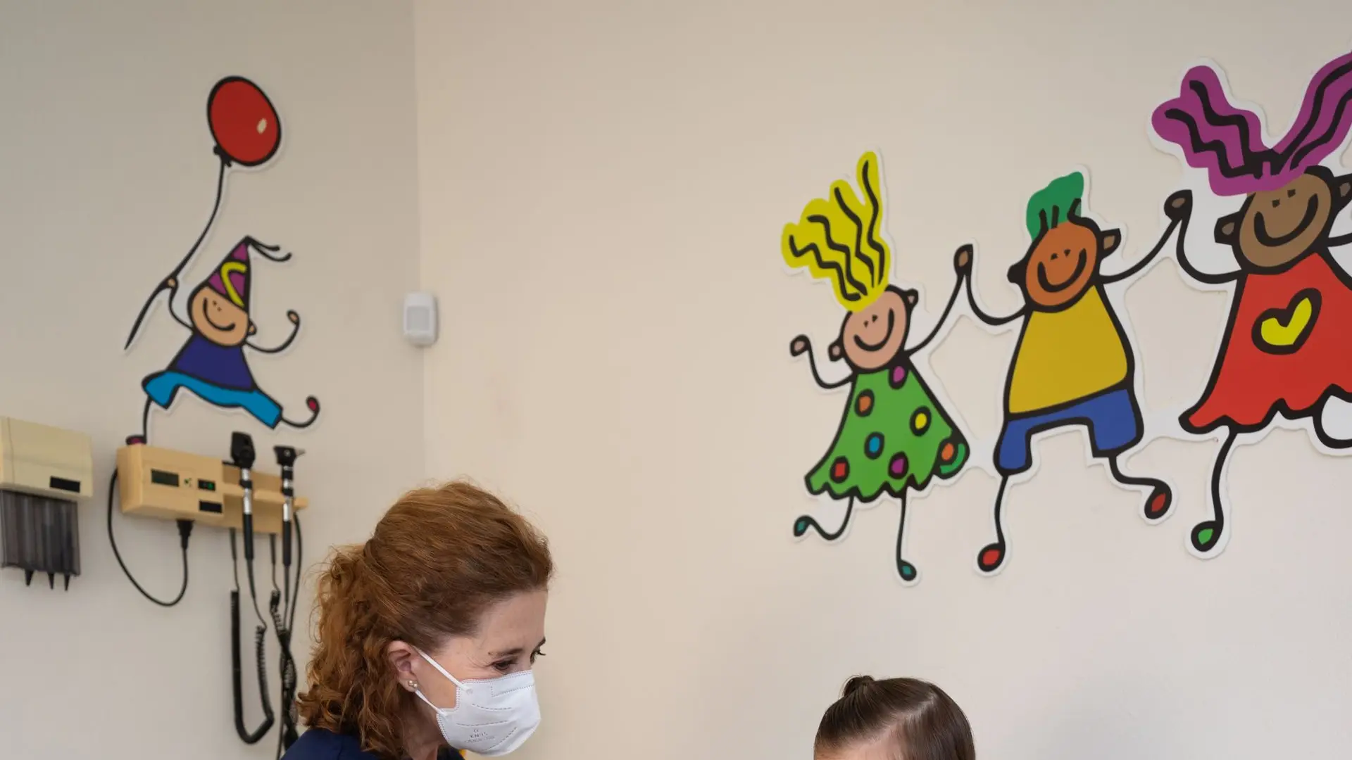 A pediatrician talks warmly with a child during a checkup
